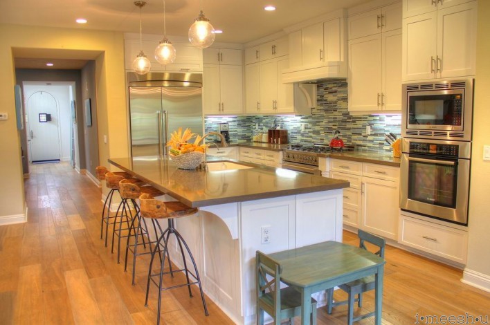 beachy kitchen with darn quartz and blue stacked tile back splash white shaker cabinets